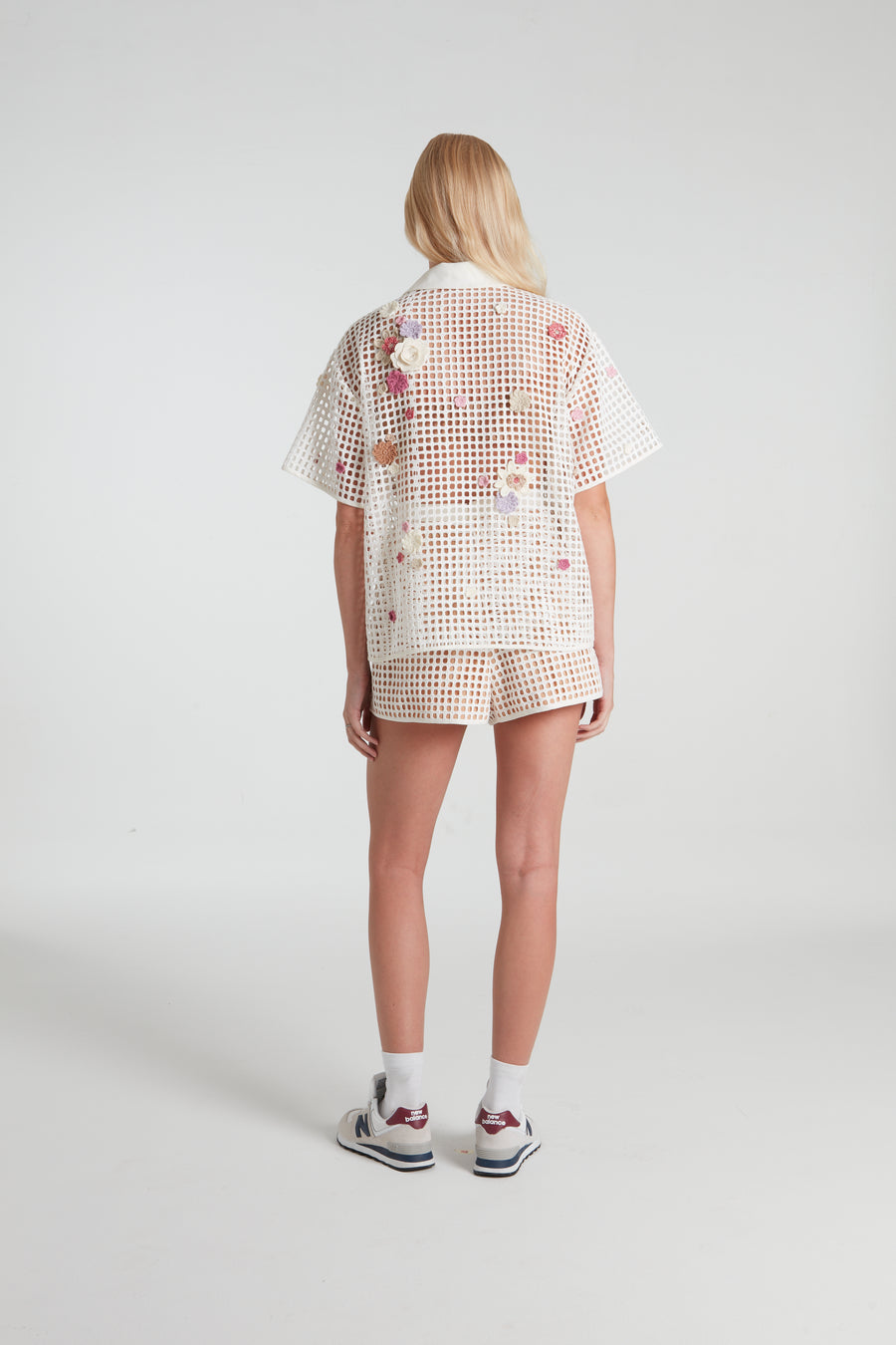 White stenciled shorts decorated with knitted flowers.