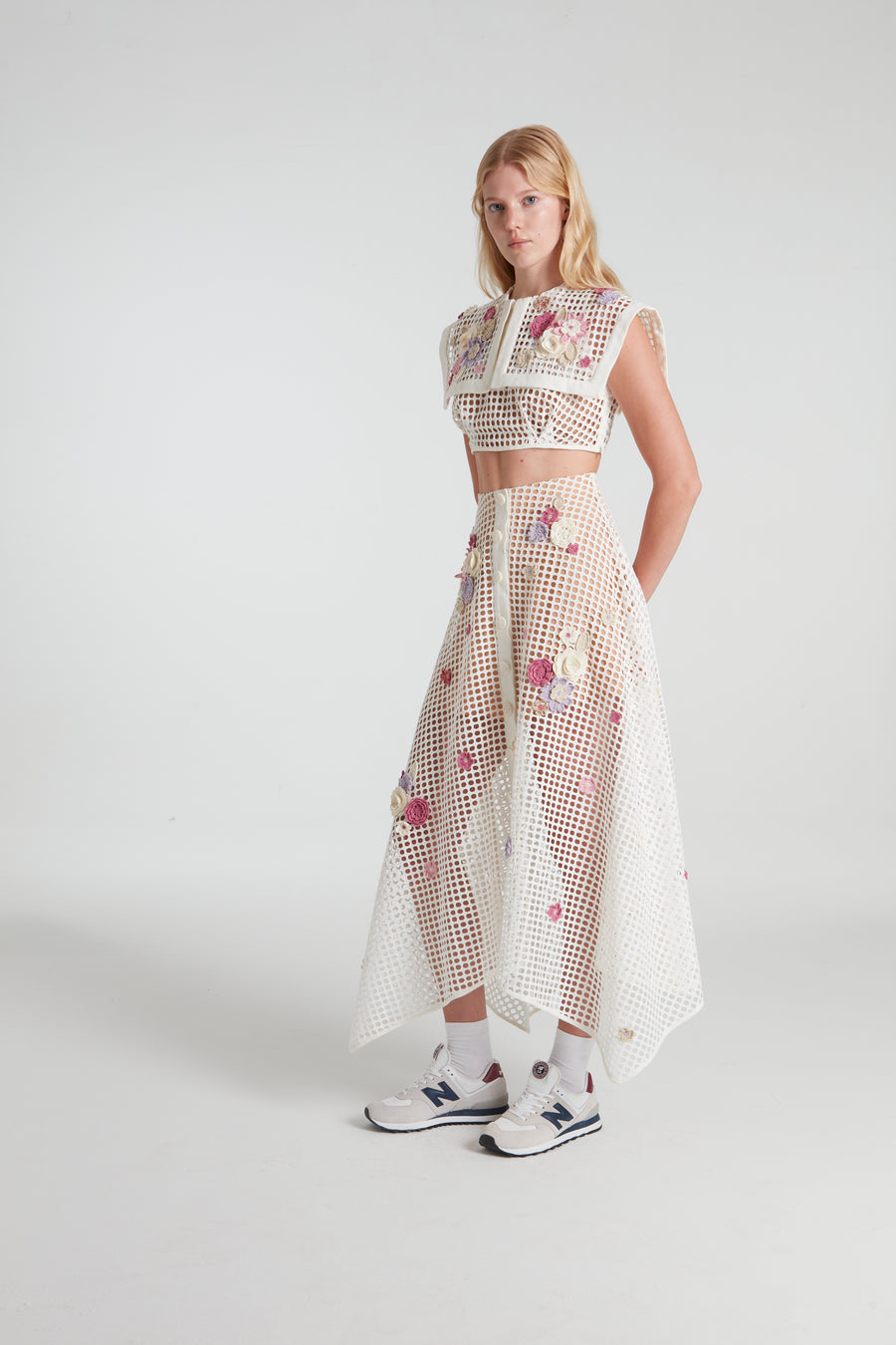 White stenciled skirt decorated with knitted flowers.